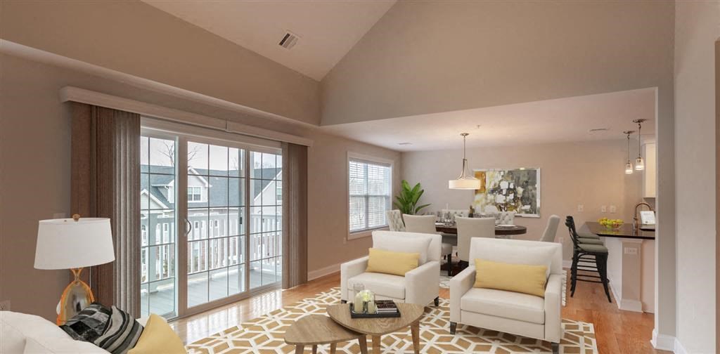 a living room with a sliding glass door and a dining room in the background at Zephyr Ridge Apartment Homes, Cedar Grove, 07009