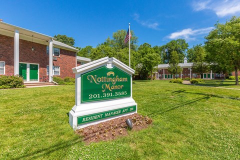a green and white sign that says northampton manor in front of a brick building at Nottingham Manor Apartments, Montvale, NJ, 07645
