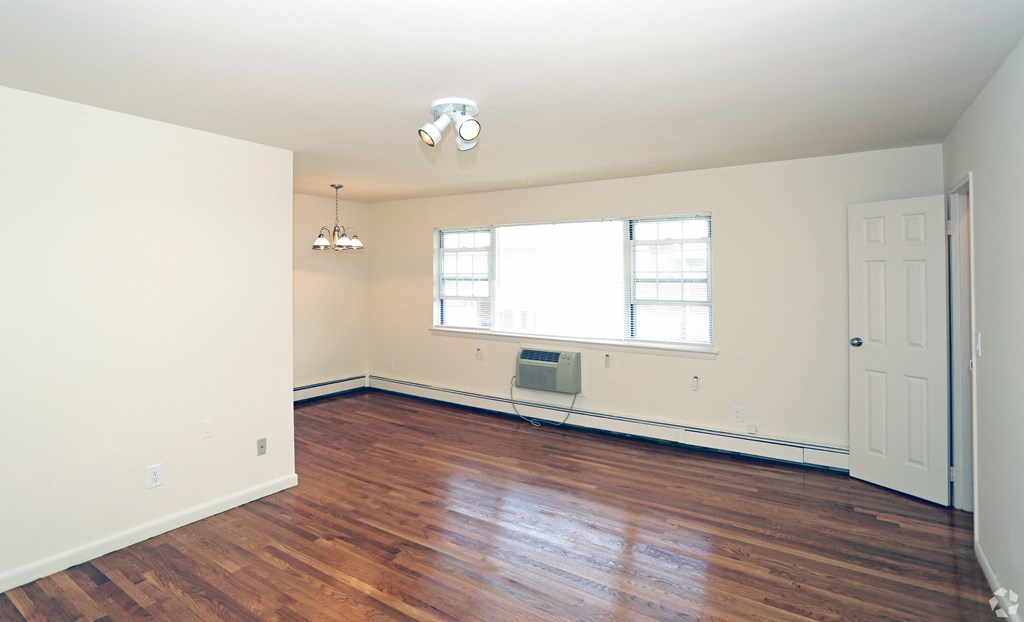 a bedroom with hardwood floors and white walls at Willow Gardens Apartments, Teaneck, 07666