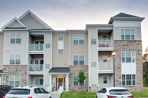 Apartment building with cars parked in front.
