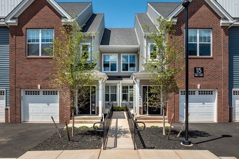 A row of houses with a bench in front of them.