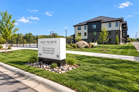 A sign for Vue Pointe in front of a building.