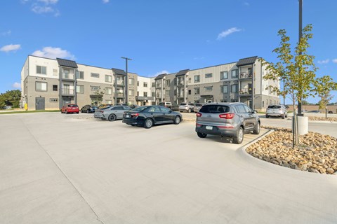 A parking lot with cars and apartment buildings in the background.