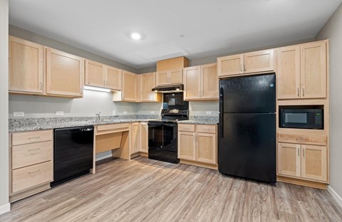 A kitchen with wooden cabinets and black appliances.
