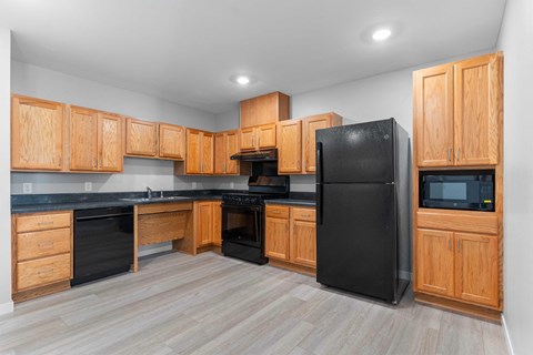 a kitchen with black appliances and wooden cabinets
