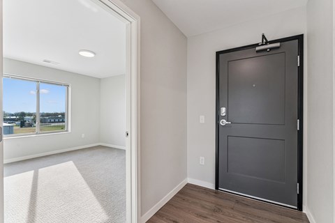 A room with a black door and a carpeted floor.