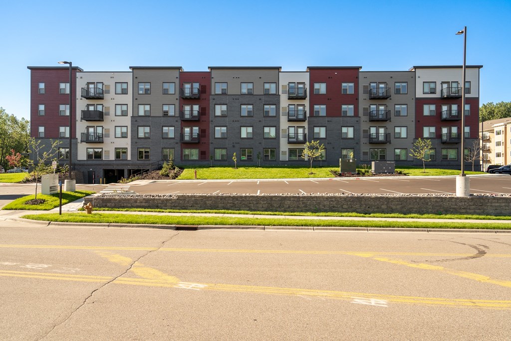 an empty parking lot in front of an apartment building