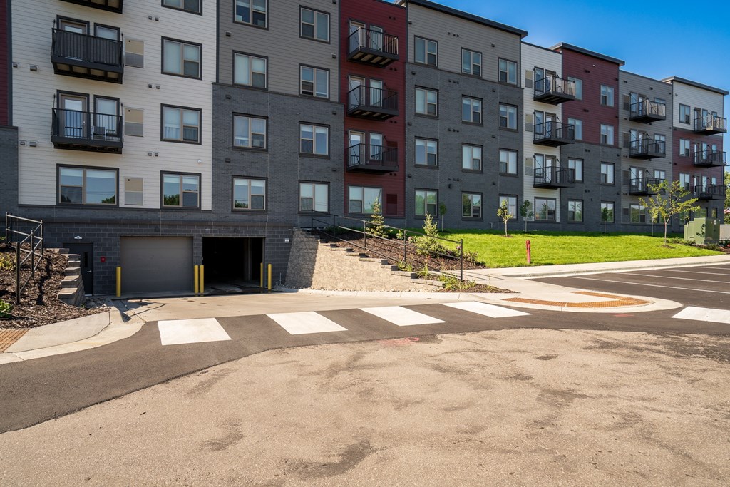 an empty parking lot in front of an apartment building
