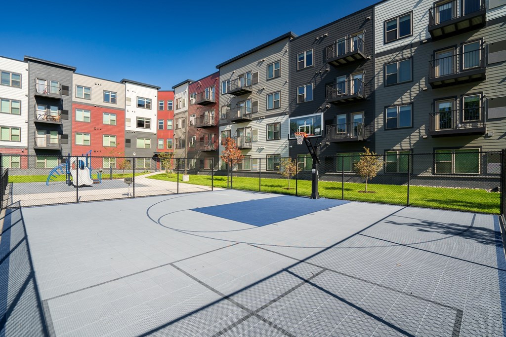 an outdoor basketball court in front of an apartment building
