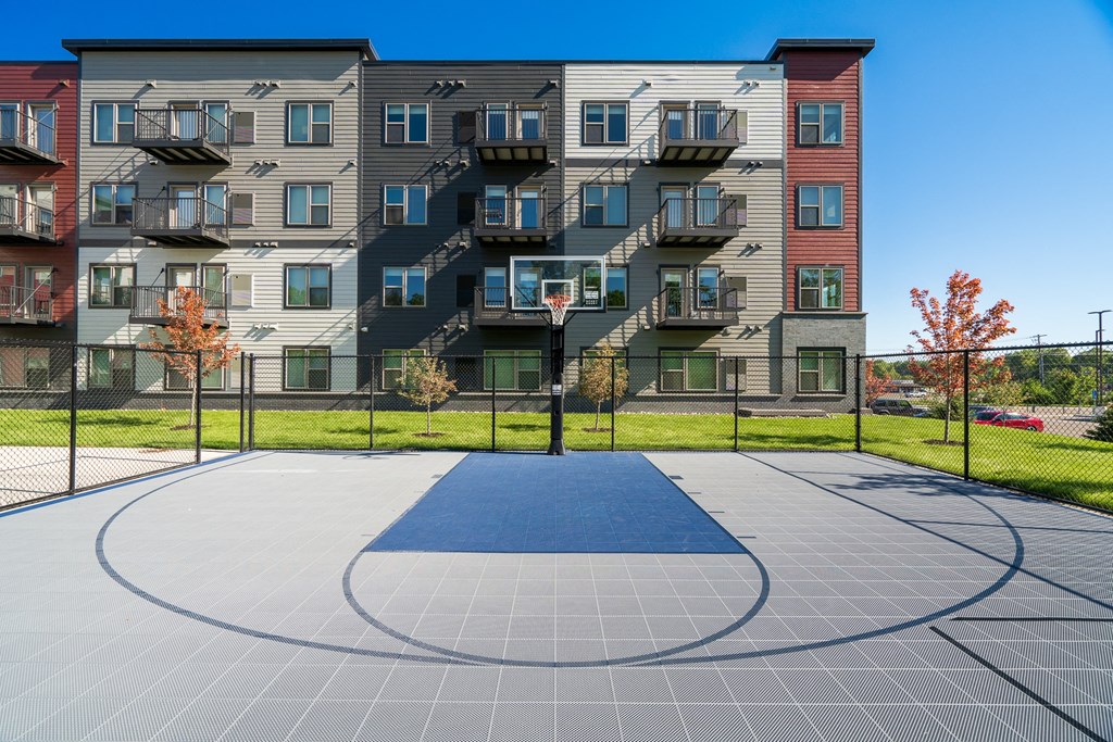 an outdoor basketball court in front of an apartment building