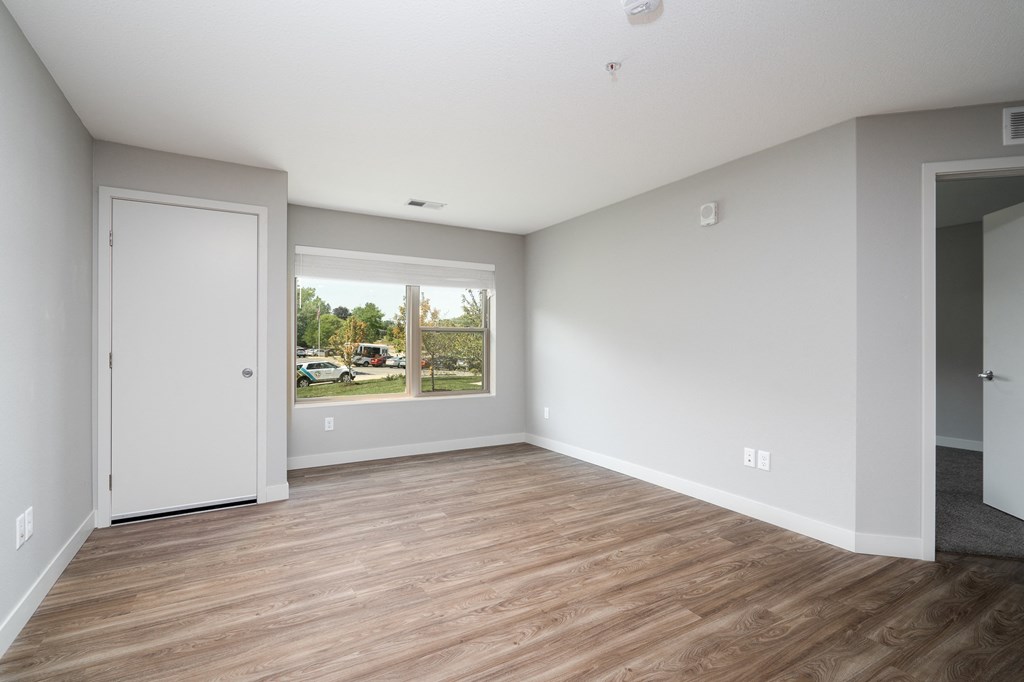 an empty living room with white walls and a window