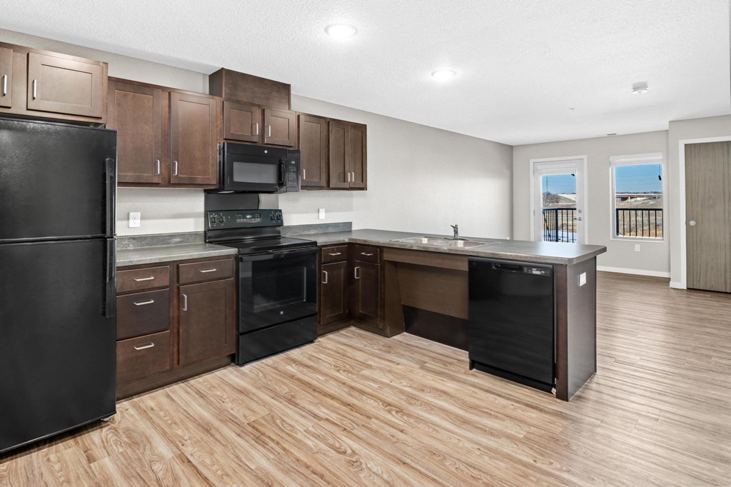 a kitchen with wooden floors and black appliances