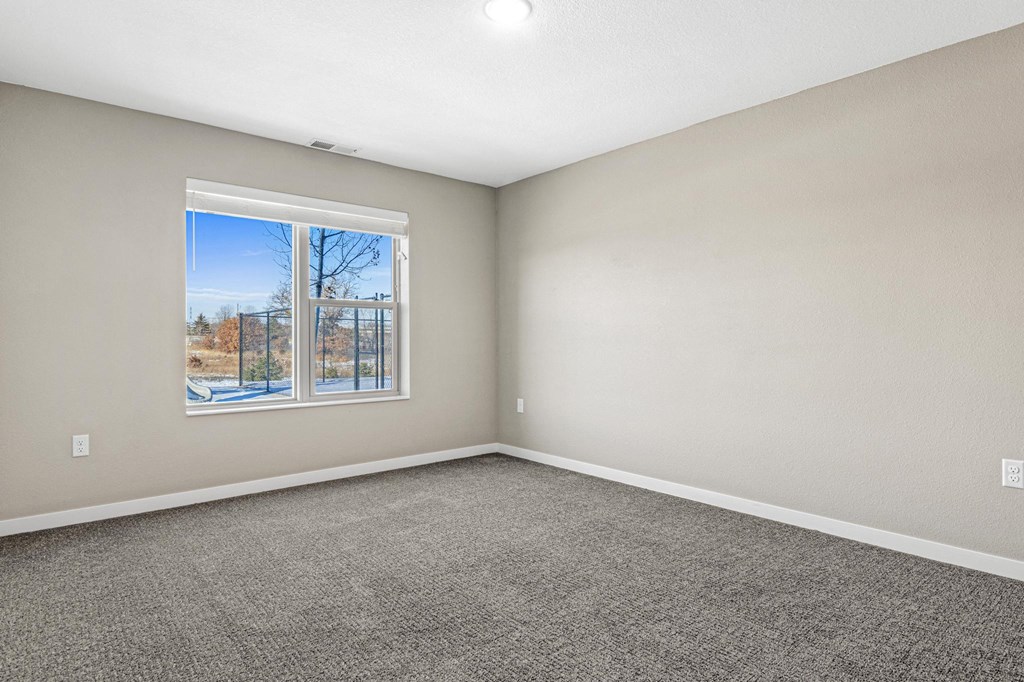 an empty room with carpet and a window