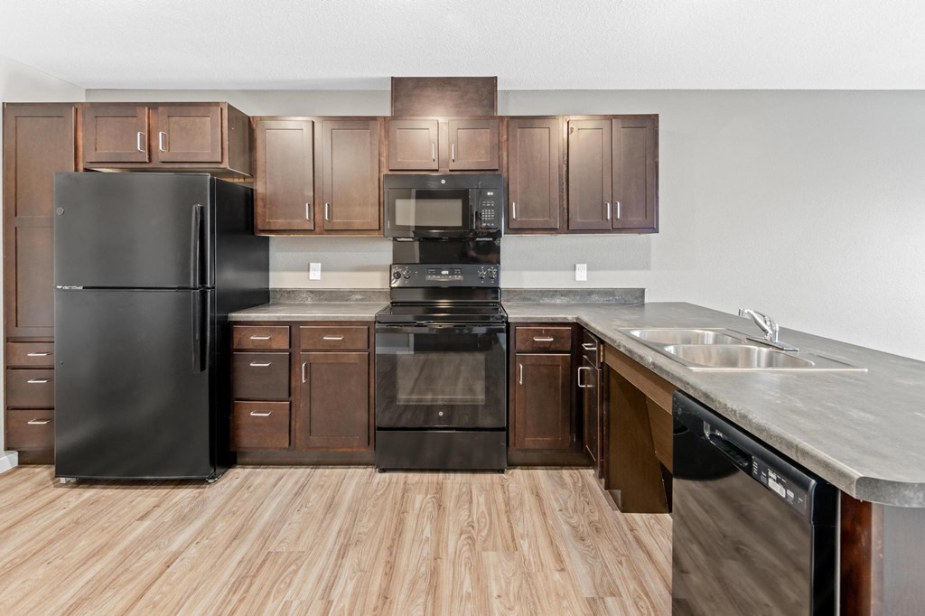 a kitchen with wooden floors and stainless steel appliances