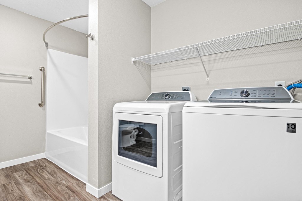 a washer and dryer in a room with a shower and a laundry closet