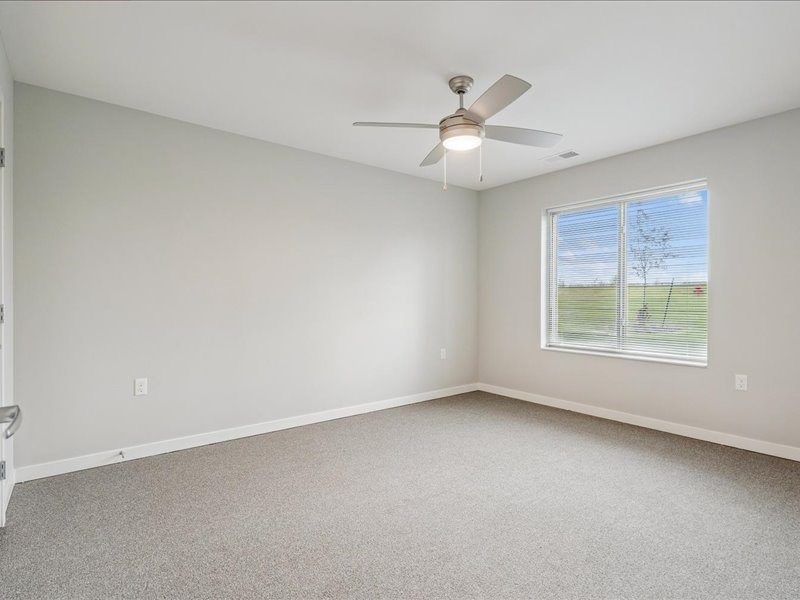 A room with a ceiling fan and a window.