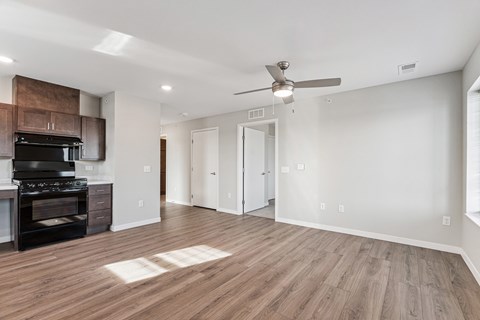 A spacious room with a ceiling fan and lighting fixtures.