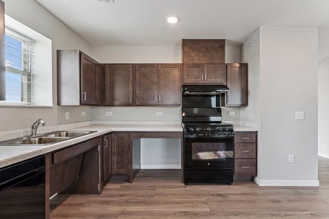 A modern kitchen with dark wood cabinets and a black stove top oven.