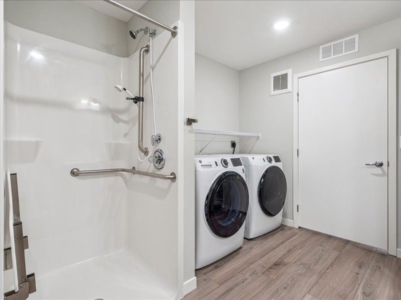 A white bathroom with a washer and dryer in it.