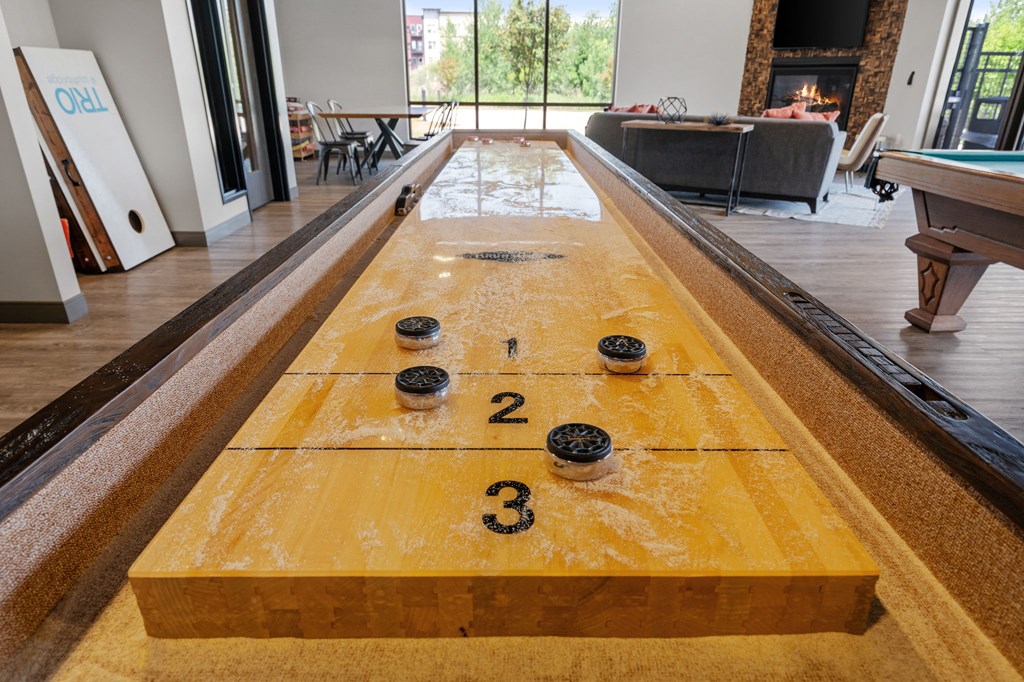 a shuffleboard table in the clubhouse of TRIO @ Southbridge apartments