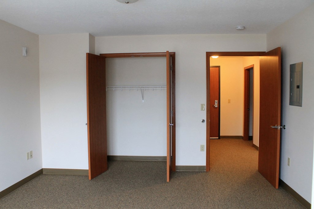 A room with a carpeted floor and two open doors.