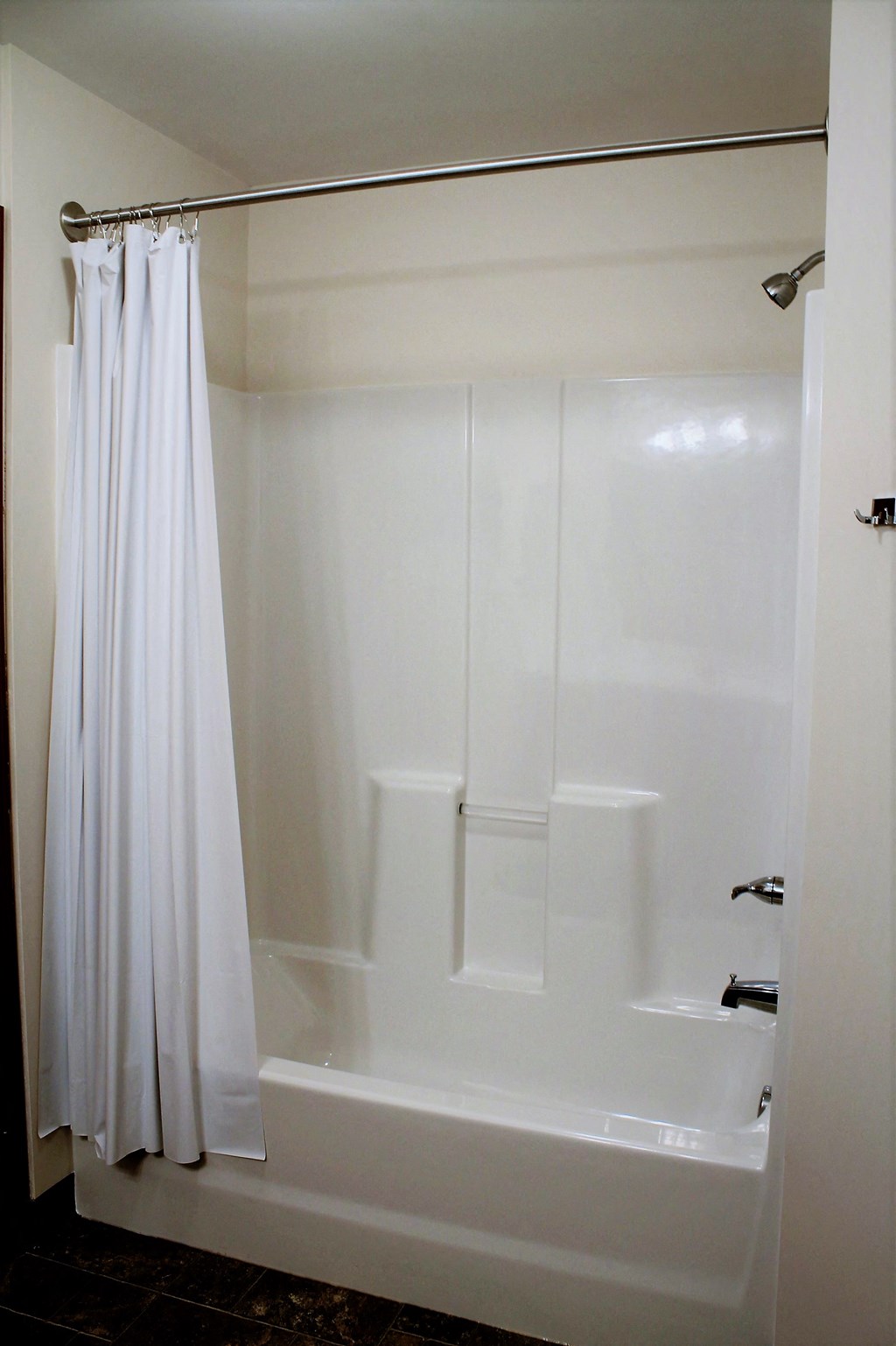 A white bathroom with a white tub and shower curtain.