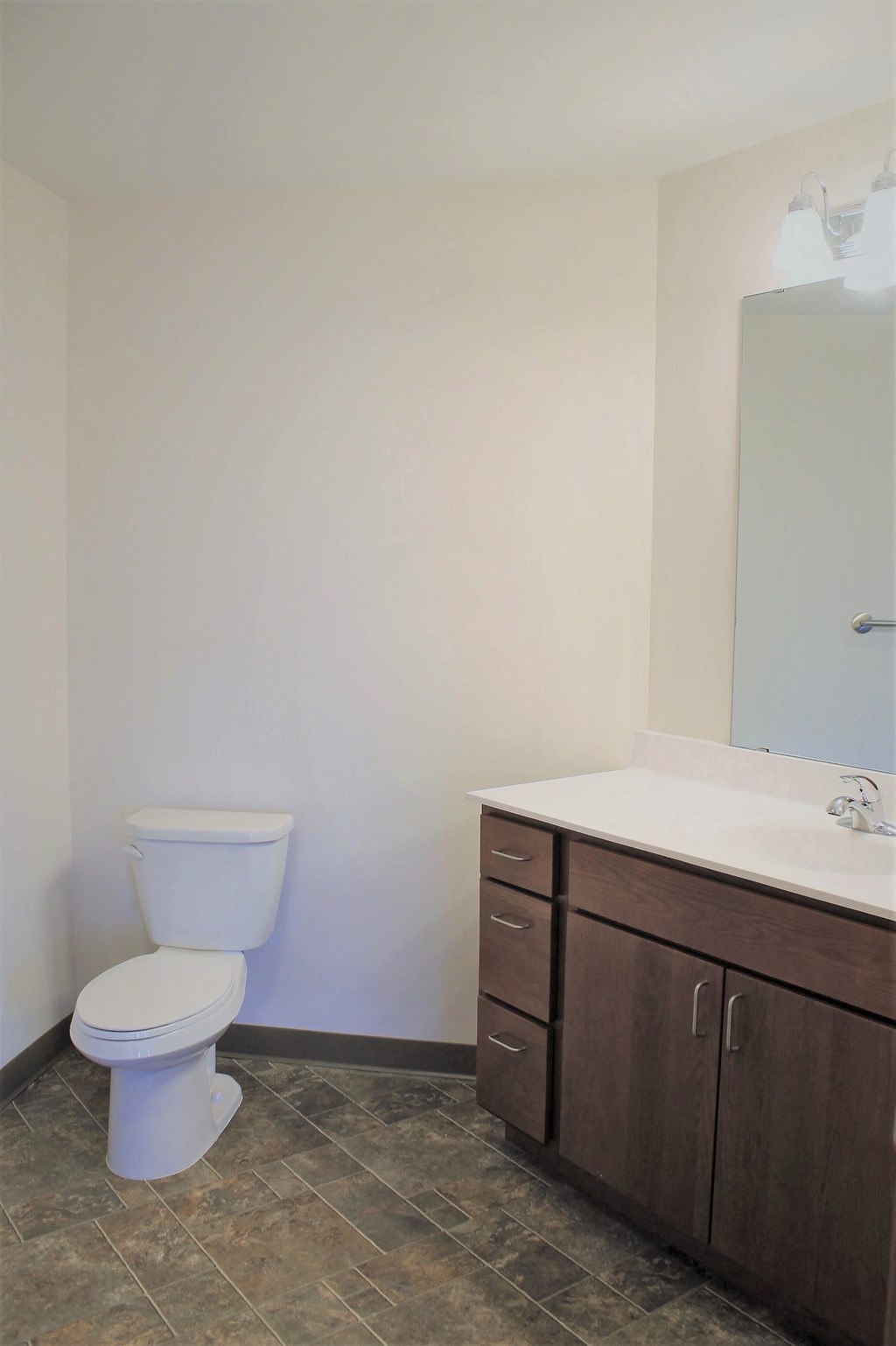 A white toilet sits in a bathroom next to a sink.