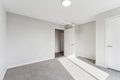 A room with a carpeted floor and a white door.