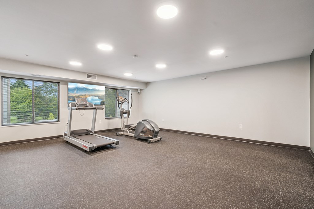 A room with a treadmill and exercise bike.