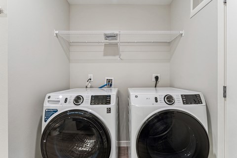 Two front load washing machines in a small laundry room.
