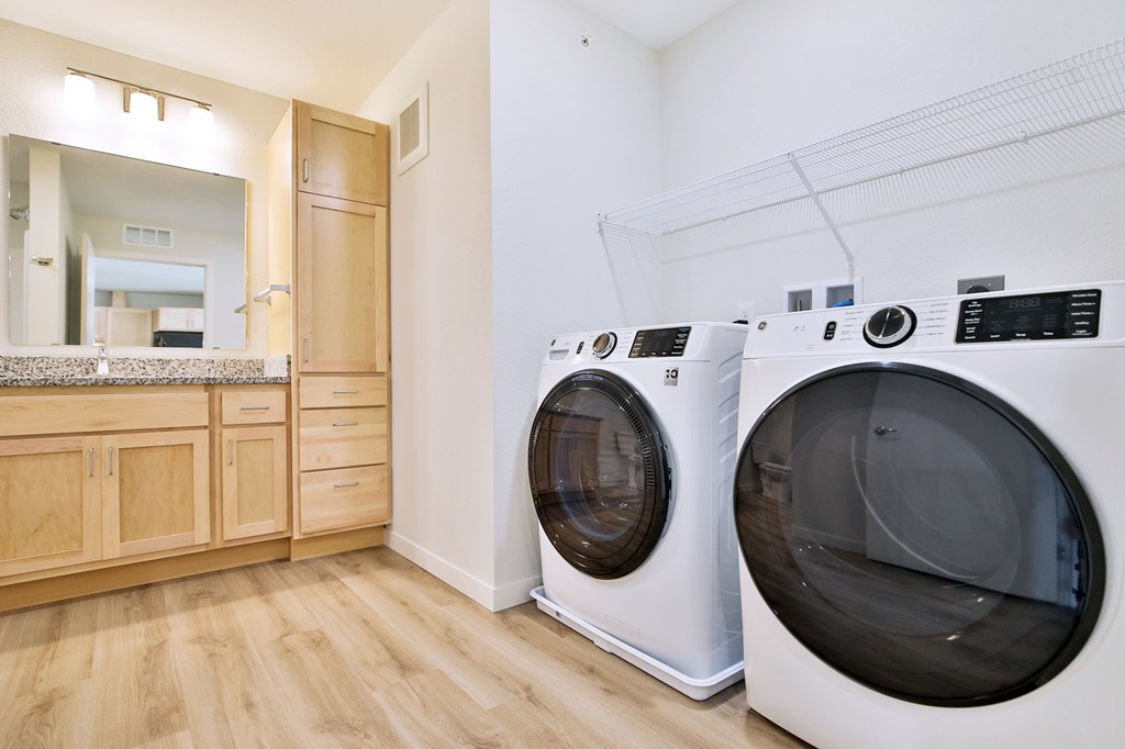 A laundry room with two front loading washing machines.