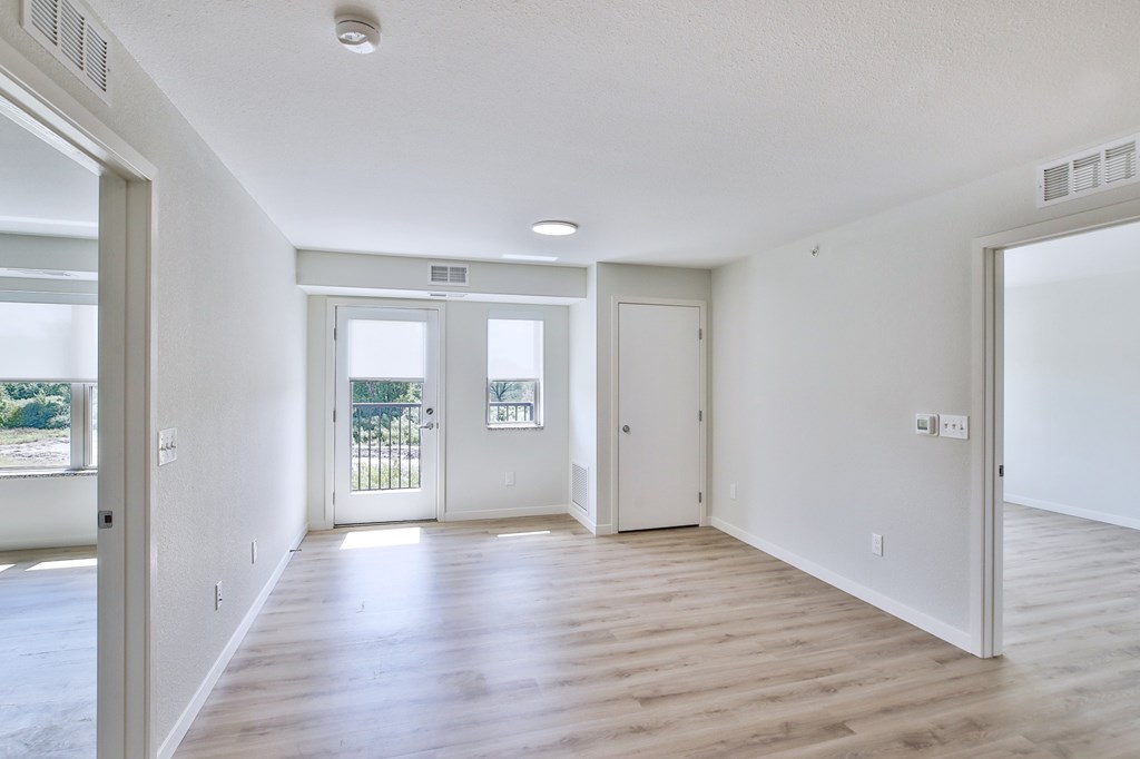A large empty room with wooden floors and white walls.