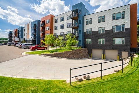 a view of an apartment complex with cars parked in a parking lot