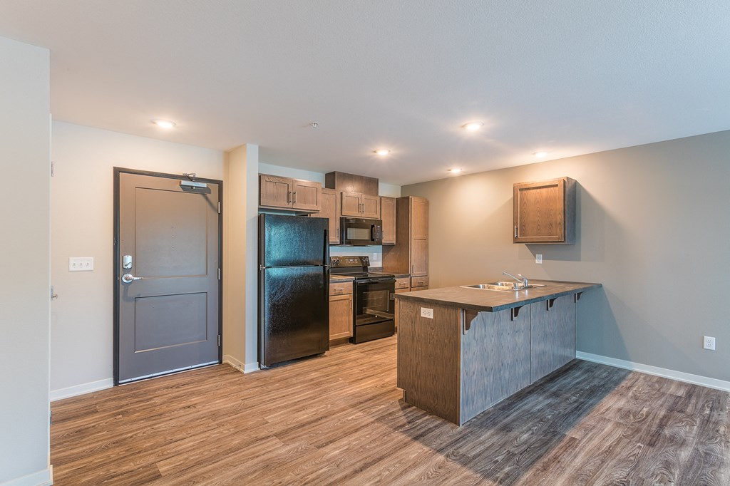 an empty kitchen with a refrigerator and a sink