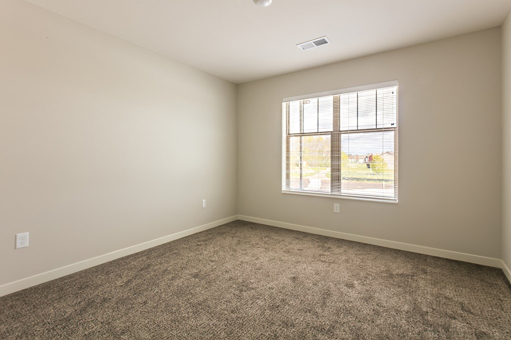 an empty room with carpet and a window