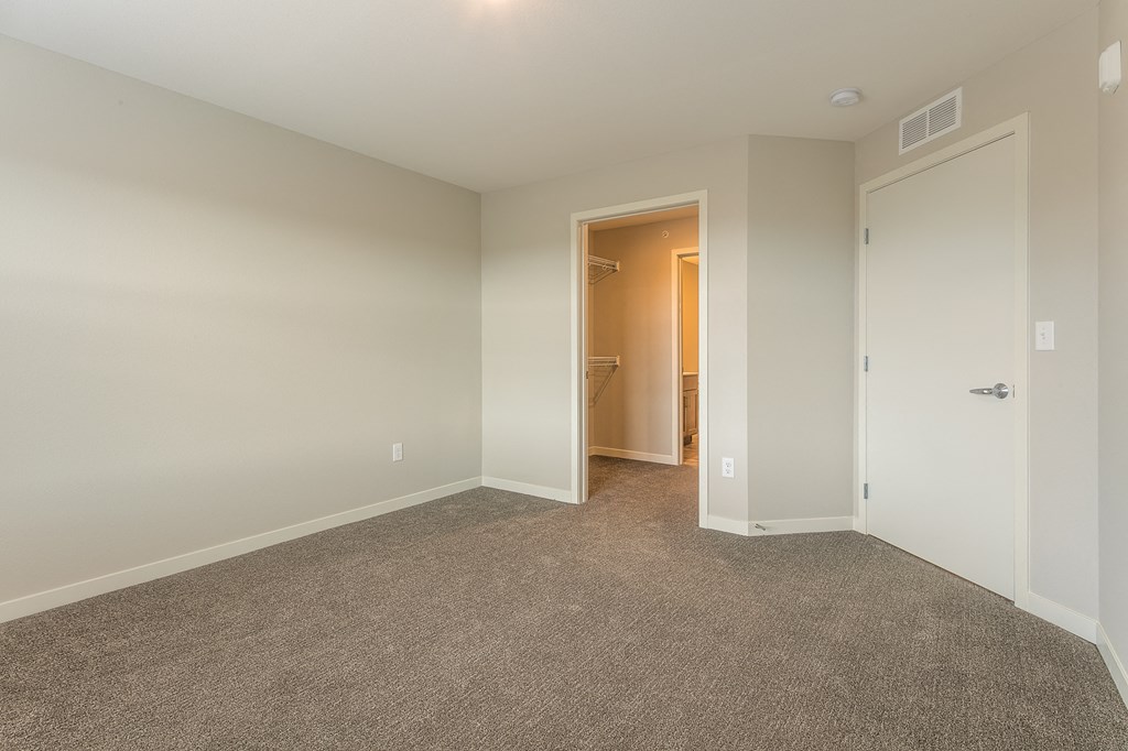 a bedroom with a closet and a door to a bathroom