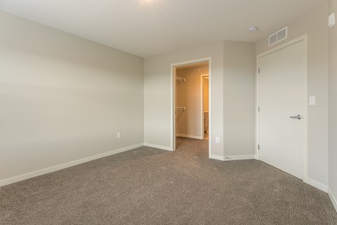 a bedroom with a closet and a door to a bathroom