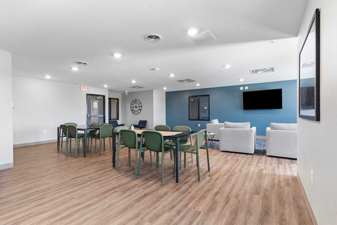 a dining room with tables and chairs and a tv on the wall
