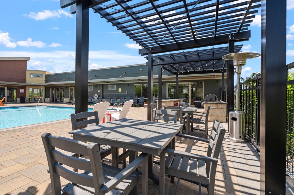 a patio with tables, chairs and a pool at TRIO @ Southbridge apartments