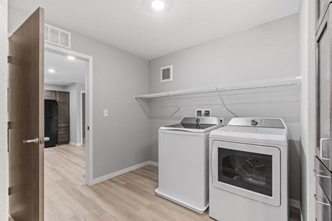 A kitchen with a white oven and a white microwave.