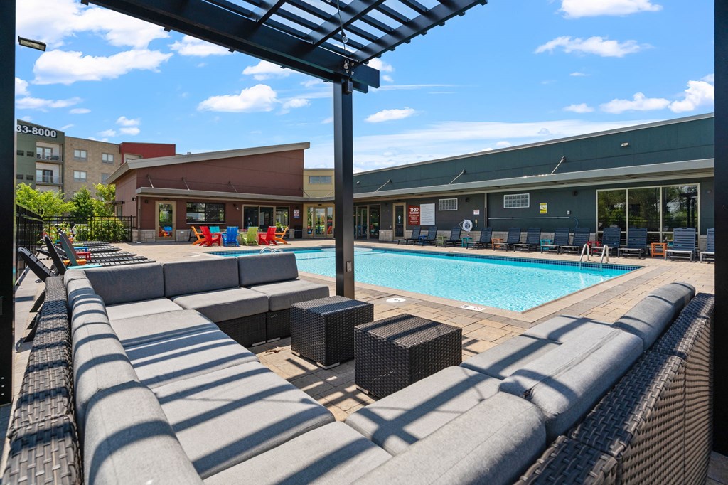 a swimming pool with lounge chairs at TRIO @ Southbridge apartments