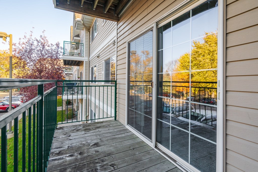 the deck of a home with large windows and a balcony