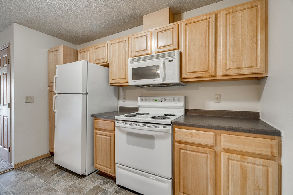 a kitchen with white appliances and wooden cabinets