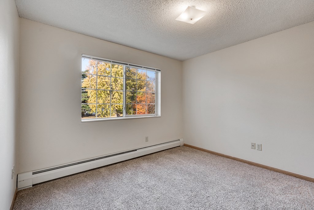 the living room of an empty home with a large window