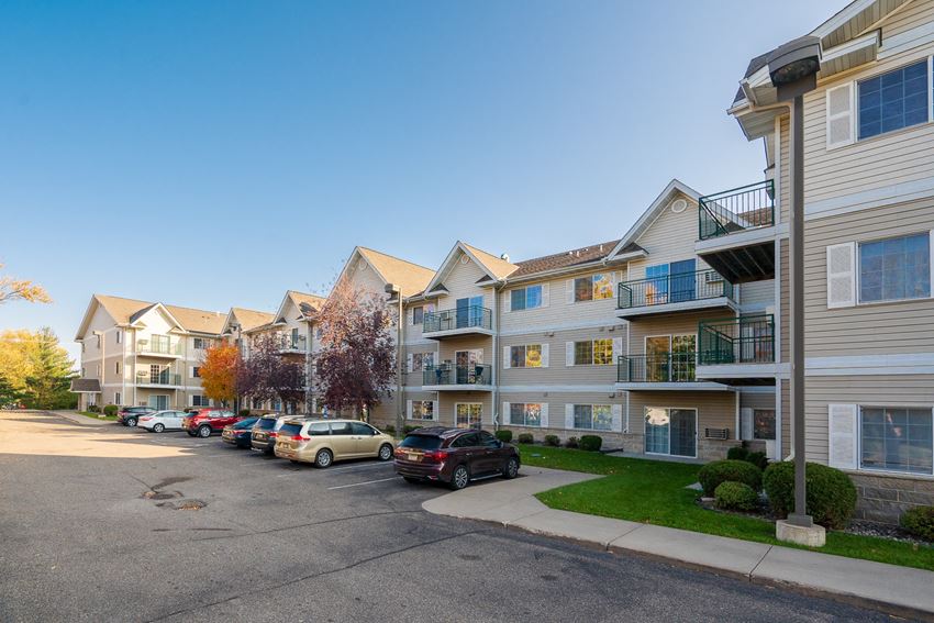 a row of houses with cars parked in front of them