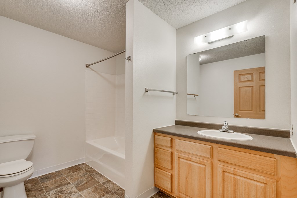 the bathroom of a rental house with a toilet sink and shower