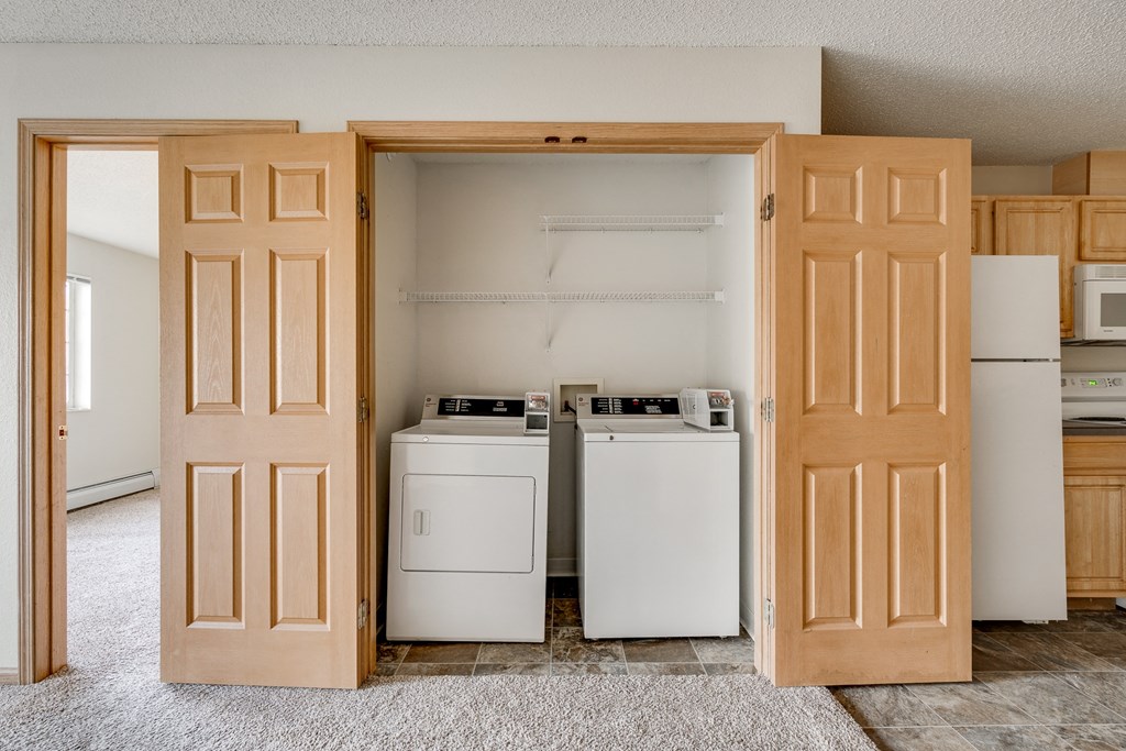 a kitchen with two washes and a refrigerator and a door open to a room