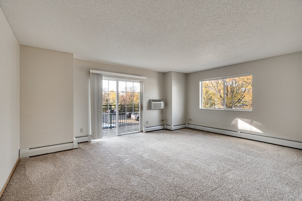 an empty living room with a door to a balcony