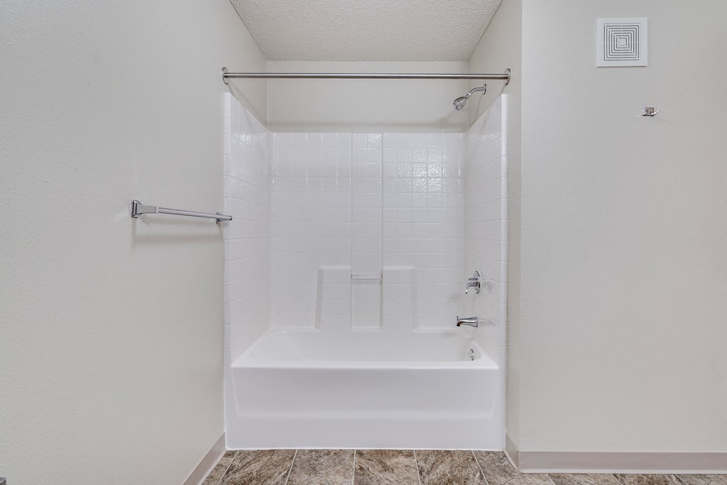 a white bathroom with a shower and a tub