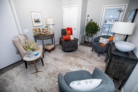 A living room with a grey couch and a grey armchair.